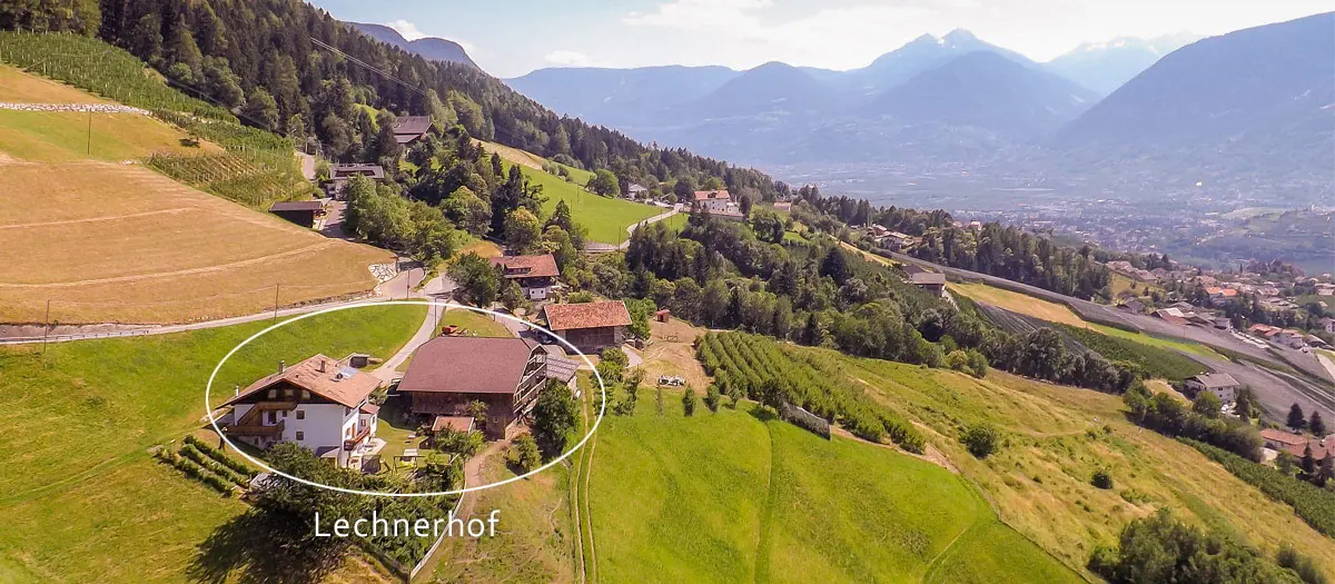 Luftaufnahme des Lechnerhofs in den Wiesen oberhalb von Schenna